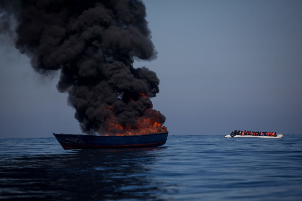 a boat owned by traffickers is torched after migrants transferred